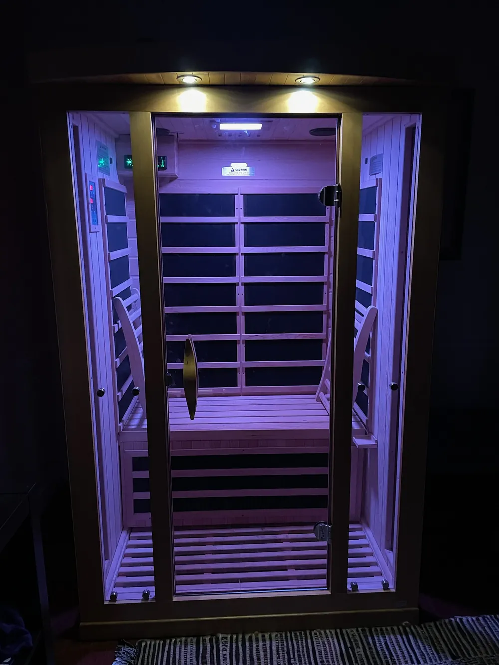 The infrared sauna cabin lit violet in the evening